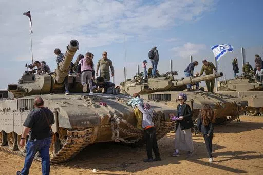 Israelis stand on tanks during an event for families of reservists outside a military base in southern Israel, Tuesday, Feb. 27, 2024. Israel and Hamas are inching toward a new deal that would free some of the roughly 130 hostages held in the Gaza Strip in exchange for a weeks-long pause in the war, now in its fifth month. A deal would bring some respite to desperate people in Gaza, who have borne a staggering toll in the war, as well as to the anguished families of hostages taken during Hamas' 