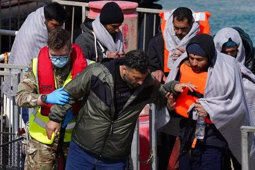 A group of people thought to be migrants are brought in to Dover, Kent, by the RNLI, following a small boat incident in the Channel, Thursday April 14, 2022. Britain's Conservative government has struck a deal with Rwanda to send some asylum-seekers thousands of miles away to the East African country, a move that opposition politicians and refugee groups condemned as inhumane, unworkable and a waste of public money. (Gareth Fuller/PA via AP)