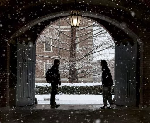 Wheaton College students stop to chat on the Norton, Mass. campus, Feb. 13, 2024 as snow falls. More than 75 million student loan borrowers have enrolled in the U.S. government's newest repayment plan since it launched in August. (Mark Stockwell/The Sun Chronicle via AP, File)