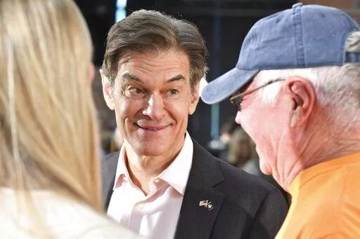 Mehmet Oz, the TV celebrity and heart surgeon who is running for the Republican nomination for U.S. Senate in Pennsylvania, talks with attendees Bob and Eileen Walker after Oz spoke at a town hall-style event at the Newtown Athletic Club, Feb. 20, 2022, in Newtown, Pa. (AP Photo/Marc Levy)