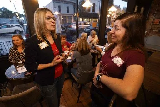 Kelly Dillaha, left, talks with Kathy Nitz during a Red Wine and Blue event in Utica, Mich., Tuesday, Sept. 20, 2022. (AP Photo/Paul Sancya)