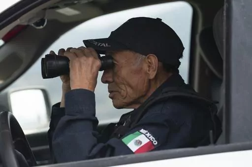 Nefi de Aquino, who works as a police officer and is also paid to keep an eye on the activity of the Popocatépetl volcano, looks at the volcano through his binoculars from Santiago Xalitzintla, Mexico, Thursday, 25 May 2023. De Aquino has been observing and reporting on the volcano´s activity since it started erupting again in 1994. (AP Photo/Marco Ugarte)