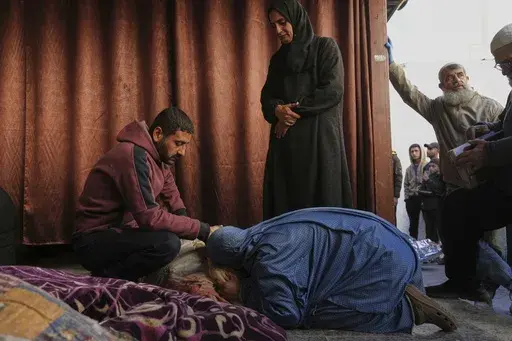 Members of the Al-Kahlout family mourn over the bodies of their relatives killed during an Israeli army strike before their burial at the Baptist hospital in Gaza City, Monday, March 24, 2025.(AP Photo/Jehad Alshrafi)