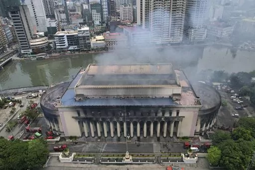 Smoke billows from the still smoldering Manila Central Post Office as a fire hits early Monday, May 22, 2023 in Manila, Philippines. A massive fire tore through Manila's historic post office building overnight, police and postal officials said Monday. (AP Photo/Aaron Favila)