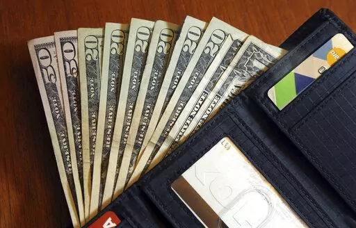 In this June 15, 2018, file photo, cash is fanned out from a wallet in North Andover, Mass.  Heading into the second half of 2022, it’s a good time to pause and check in on your financial life. But what should your midyear money checklist include?   (AP Photo/Elise Amendola, File)