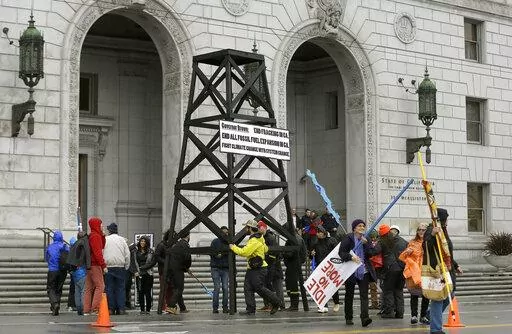 Protesters prepare to take down a makeshift oil derrick that was set up in front of the California State Office Building to protest fracking in San Francisco on Feb. 6, 2015. Leasing for new oil and gas drilling on federal land in central California is temporarily blocked under a settlement announced Monday, Aug. 1, 2022, between the state and the U.S. Bureau of Land Management. (AP Photo/Jeff Chiu, File)