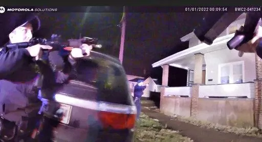This still image taken from from Canton Police Department body camera video shows officers holding up their weapons before entering a house Saturday, Jan. 1, 2022, in Canton, Ohio. James Williams, 46, of Canton, was shot in the chest and pronounced dead at a nearby hospital. (Canton Police Dept. via AP)