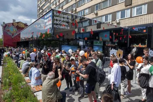 People lineup to visit a newly opened fast food restaurant in a former McDonald's outlet in Bolshaya Bronnaya Street in Moscow, Russia, Sunday, June 12, 2022. The sign reads 'The Name Changes, Love Remains'. The first of former McDonald's restaurants is reopened with new branding in Moscow. The corporation sold its branches in Russia to one of its local licensees after Russia sent tens of thousands of troops into Ukraine. (AP Photo/Dmitry Serebryakov)