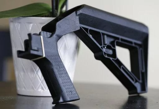 In this March 15, 2019, file photo, a bump stock is displayed in Harrisonburg, Va. A legal challenge to the Trump administration’s ban on bump stocks — devices attached to semiautomatic firearms so that a shooter can fire multiple rounds with a single trigger pull — was revived Thursday, June 23, 2022 by a federal appeals court. (AP Photo/Steve Helber, File)