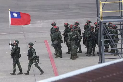 A soldier holds up Taiwan’s national flag during the annual Han Kuang military exercises in Taoyuan, Northern Taiwan, on July 26, 2023. Taiwan’s government is racing to counter China’s military, but many on the island say they don’t share the sense of threat. (AP Photo/Chiang Ying-ying, File)