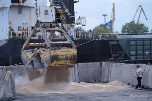 Workers load grain at a grain port in Izmail, Ukraine, on April 26, 2023. Russia has repeatedly fired missiles and drones at Ukrainian ports key to sending grain to the world. Moscow has declared large swaths of the Black Sea dangerous for shipping. (AP Photo/Andrew Kravchenko, File)