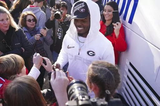 Georgia linebacker Nakobe Dean is greeted by a large crowd of fans as he and his teammates return to the Georgia campus, Tuesday, Jan. 11, 2022, in Athens, Ga., after defeating Alabama in the College Football Championship NCAA college football game. (AP Photo/John Bazemore)
