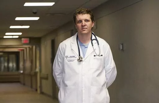 Dr. Connor McNamee, a third-year family medicine resident at the University of Toledo Medical Center, poses at the medical center, Tuesday, Oct. 18, 2022, in Toledo, Ohio. Students in obstetrics-gynecology and family medicine are facing tough choices about where to advance their training in a landscape where legal access to abortion varies from state to state. McNamee began exploring abortion training outside Ohio last summer. A state law bans most abortions after cardiac activity is detected, b