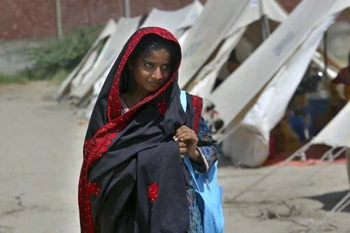 Flood victim Rajul Noor walks towards her tent school at a relief camp, in Dadu, a district of southern Sindh province, Pakistan, Sept. 23, 2022. Every part of Noor’s life has been wrecked by this summer’s massive monsoon-driven floods. The 12-year-old girl’s family home is destroyed, as is the school that she loved. The devastation wreaked by floods in Pakistan this summer has intensified the debate over a question of climate justice: Do rich countries whose emissions are the main cause o