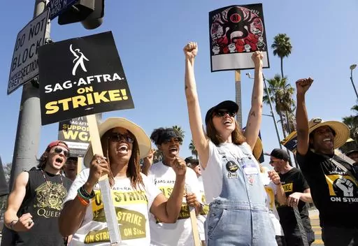 Striking actors Jennifer Leigh Warren, left, and Emily Kincaid, right, demonstrate outside Netflix studios, Tuesday, Oct. 17, 2023, in Los Angeles. (AP Photo/Chris Pizzello)