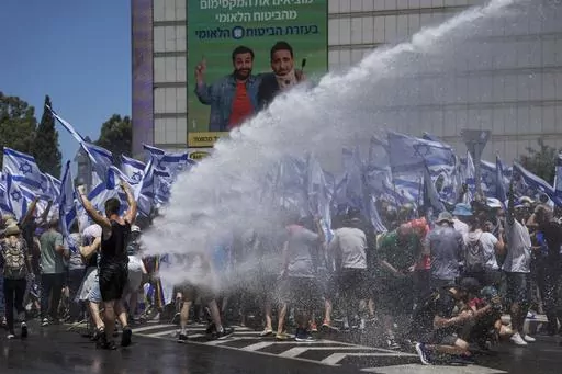 Israeli police use a water cannon to disperse demonstrators blocking a road during a protest against plans by Prime Minister Benjamin Netanyahu's new government to overhaul the judicial system, in Tel Aviv, Israel, Tuesday, July 11, 2023. Protesters in Israel are blocking highways to major cities on a day of countrywide demonstrations against the government's divisive plan to overhaul the judiciary. The demonstrations on Tuesday came hours after Prime Minister Benjamin Netanyahu's parliamentary 