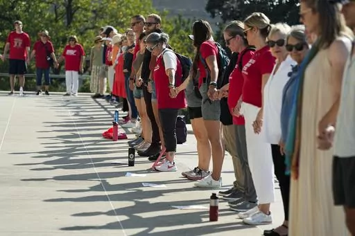 People hold hands around the State Capitol during a prayer session before a special session of the state legislature on public safety Monday, Aug. 21, 2023, in Nashville, Tenn. (AP Photo/George Walker IV)