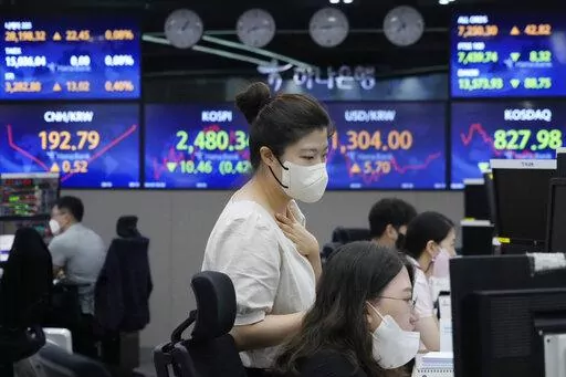 Currency traders watch monitors at the foreign exchange dealing room of the KEB Hana Bank headquarters in Seoul, South Korea, Monday, Aug. 8, 2022. Asian stocks were mixed Monday after strong U.S. jobs data cleared the way for more interest rate hikes and Chinese exports rose by double digits. (AP Photo/Ahn Young-joon)