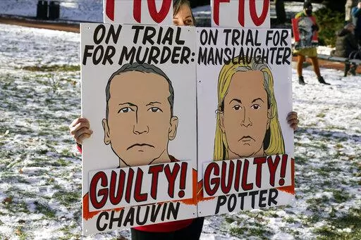 A demonstrator holds up "GUILTY" signs at the Hennepin County Government Center, Dec. 23, 2021, in Minneapolis, where jurors found former suburban Minneapolis police officer Kim Potter guilty of first degree and second degree manslaughter in the death of motorist Daunte Wright during a traffic stop. Data show it's rare for police officers to be convicted of on-duty killings. But three recent convictions of police officers in Minnesota have some people wondering whether that's changing. (AP Photo