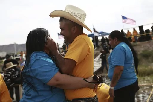 People living in the U.S. embrace with people living in Mexico during the 10th annual "Hugs not Walls" event, on a stretch of the Rio Grande, in Ciudad Juarez, Mexico, Saturday, May 6, 2023. The brief family reunions are part of a campaign sponsored by the Border Network for Human Rights, an immigration rights group. (AP Photo/Christian Chavez)