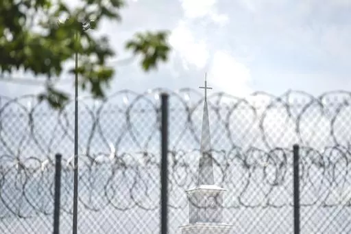 A church steeple peaks over the barbed-wire fence following the dedication of the newly constructed chapel at the Mississippi Correctional Institute for Women (MCIW) at Central Mississippi Correctional Facility in Pearl, Miss., June 15, 2023. A former Mississippi prison guard on Thursday, July 27, pleaded guilty to deprivation of an inmate's rights by using excessive force when she was a corrections officer at the Central Mississippi Correctional Facility, the U.S. Justice Department said. (Hann