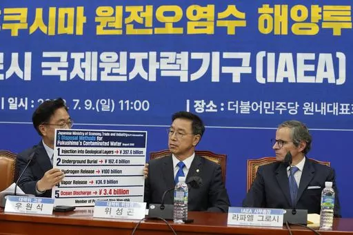 Main opposition Democratic Party lawmaker Woo Won-shik, left, shows a list of proposed disposal methods for the Fukushima contaminated water as his party lawmaker Wi Seong-gon and Rafael Mariano Grossi, Director General of the International Atomic Energy Agency, right, look on during a meeting with the party's lawmakers at the National Assembly in Seoul, South Korea, Sunday, July 9, 2023. (AP Photo/Ahn Young-joon)