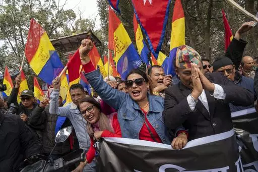 Supporters of Rastriya Prajatantra Party, or national democratic party, wave their flags during a pro-monarchy protest in Kathmandu, Nepal, Feb. 21, 2024. Nepal’s once unpopular monarchy — abolished after centuries of rule over the Himalayan nation — is hoping to regain some of its lost glory. Royalist groups and supporters of former King Gyanendra have been holding rallies to demand the restoration of the monarchy and the nation’s former status as a Hindu state. (AP Photo/Niranjan Shres