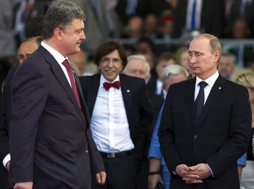 Ukrainian President Petro Poroshenko, left, walks past Russian President Vladimir Putin, right, during the commemoration of the 70th anniversary of the D-Day in Ouistreham, western France, June 6, 2014. The 2015 peace deal for eastern Ukraine was a diplomatic coup for Moscow, requiring Ukrainian authorities to offer self-rule to the Russia-backed separatist regions. (AP Photo/Alexander Zemlianichenko, file)