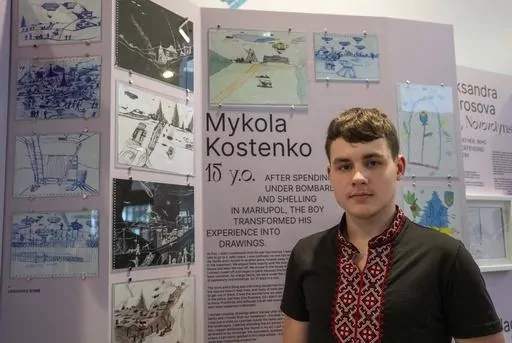 Drawings by Mykola Kostenko, pictured, are part of the War Diaries exhibition, showcasing the personal diaries of Ukrainian children who have witnessed the war, hosted by the Amsterdam city hall , Netherlands, Thursday, Aug. 17, 2023. The city where Anne Frank wrote her World War II diary while hiding with her family from the brutal Nazi occupation is hosting an exhibition with grim echoes of her plight more than three quarters of a century later.(AP Photo/Peter Dejong)