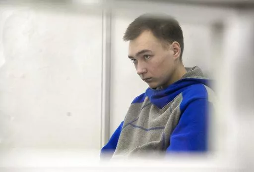 Russian army Sergeant Vadim Shishimarin, 21, is seen behind a glass during a court hearing in Kyiv, Ukraine, Monday, July 25, 2022. Kyiv Appeal court has started to consider an appeal on a life sentence for Shishimarin after he was sentenced for the killing of a 62-year-old man who was shot in the head in a village in the northeastern Sumy region in the opening days of the war. (AP Photo/Danylo Antoniuk)