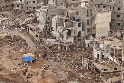 Rescuers and relatives of victims set up tents in front of collapsed buildings in Derna, Libya, Monday, Sept. 18, 2023. Some 11,300 people died when two dams collapsed during Mediterranean storm Daniel last week sending a wall of water gushing through the city, according to the Red Crescent aid group. A further 10,000 people are missing, and presumed dead. (AP Photo/Muhammad J. Elalwany)