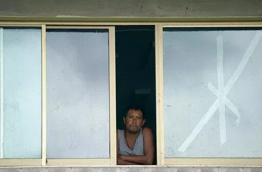 A man looks out of a window of a school that was used as a refuge from Hurricane Orlene in Escuinapa, Mexico, Monday, Oct. 3, 2022. Hurricane Orlene made landfall on Mexico's Pacific coast near the tourist town of Mazatlan on Monday before quickly weakening over western Mexico. (AP Photo/Fernando Llano)
