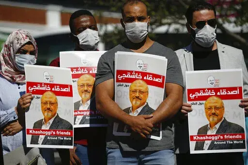 People hold posters of slain Saudi journalist Jamal Khashoggi, near the Saudi Arabia consulate in Istanbul, marking the two-year anniversary of his death, Oct. 2, 2020. A Turkish court ruled Thursday, April 7, 2022 to suspend the trial in absentia of 26 Saudis accused in the gruesome killing of Washington Post columnist Jamal Khashoggi and for the case to be transferred to Saudi Arabia. (AP Photo/Emrah Gurel, File)