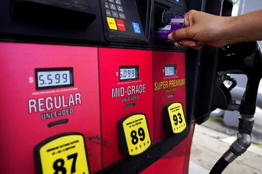 A customer holds a credit card at the pay-at-the-pump gasoline pump in Rolling Meadow, Ill., Thursday, June 30, 2022.   The U.S. economy shrank from April through June for a second straight quarter, contracting at a 0.9% annual pace and raising fears that the nation may be approaching a recession. The decline that the Commerce Department reported Thursday, July 28,  in the gross domestic product — the broadest gauge of the economy — followed a 1.6% annual drop from January through March. (AP