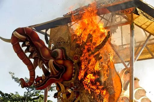 Fire engulfs a giant effigy of a mythical animal containing the remains of 117 people during a traditional mass cremation called "ngaben" on Friday, July 29, 2022, in Padangbai, Bali, Indonesia. The previously buried remains were dug up and placed in a temporary shrine before being cremated. Balinese believe that cremating the dead liberates their souls, allowing them to enter the higher world to reincarnate into better beings. (AP Photo/Firdia Lisnawati)