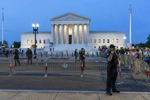 Demonstrators protest outside of the U.S. Supreme Court as law enforcement officers stand ready, May 3, 2022, in Washington. A leaked draft of a Supreme Court opinion overruling the landmark Roe v. Wade decision has thrust companies into the limelight on what’s arguably the most divisive issue in American politics. (AP Photo/Alex Brandon, File)
