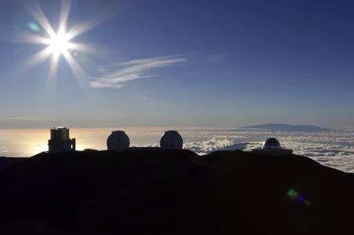 The sun sets behind telescopes on July 14, 2019, at the summit of the Big Island's Mauna Kea in Hawaii. For over 50 years, telescopes have dominated the summit of Mauna Kea, a place sacred to Native Hawaiians and one of the best places in the world to study the night sky. That's now changing with a new state law saying Mauna Kea must be protected for future generations and that science must be balanced with culture and the environment. (AP Photo/Caleb Jones, File)