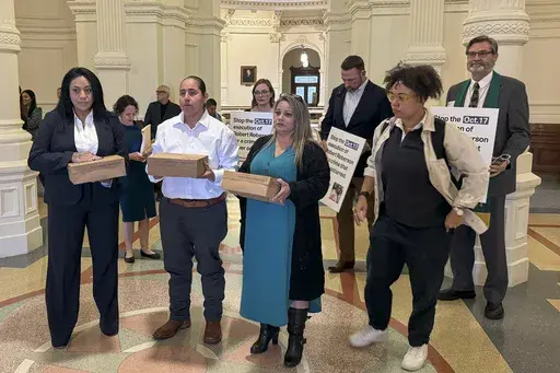 Casandra Rivera, left, Anna Vasquez, second from left, and Elizabeth Ramirez, center, of the "San Antonio 4" group, hold boxes with petitions being delivered in the Texas State capitol for Texas Gov. Greg Abbott seeking the pardoning of Robert Roberson's execution, Wednesday, Oct. 16, 2024 in Austin, Texas. Roberson, 57, is scheduled to receive a lethal injection on Oct. 17, for the 2002 killing of his 2-year-old daughter, Nikki Curtis, in the East Texas city of Palestine. Roberson has long proc