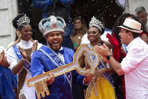 Carnival King Momo, Wilson Dias da Costa Neto, holds the key of the city as the Rio de Janeiro Mayor Eduardo Paes, right, applauds during a ceremony marking the official start of Carnival in Rio de Janeiro, Brazil, Wednesday, April 20, 2022. (AP Photo/Bruna Prado)