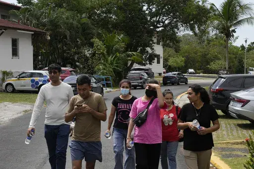 Afghan migrants deported from the U.S. walk to the UN Refugee Agency office in Panama City, Thursday, March 20, 2025, seeking advice on how and where to seek asylum. (AP Photo/Matias Delacroix)
