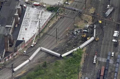FILE- In this Wednesday, May 13, 2015, file photo, emergency personnel work at the scene of a derailment in Philadelphia of an Amtrak train headed to New York. A Philadelphia jury is expected weigh criminal charges Friday, March 4, 2022, against Amtrak engineer Brandon Bostian over the deadly derailment. (AP Photo/Patrick Semansky, File)