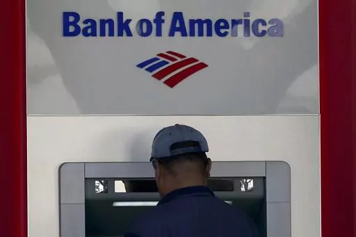 A customer uses an ATM at a Bank of America location in San Francisco, Monday, April 24, 2023. Bank of America is being ordered to pay more than $100 million to customers for double-dipping on some fees imposed on customers, withholding reward bonuses explicitly promised to credit card customers, and misappropriating sensitive personal information to open accounts without customer knowledge or authorization. (AP Photo/Jeff Chiu, File)