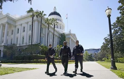 Riverside Police Lt. Kevin Kauk, left, San Bernardino Chief of Police Darren Goodman, center, an Riverside Police Chief Larry Gonzalez walk past the state Capitol where earlier in the day a "credible threat" forced California senators out of the building In Sacramento, Calif., Thursday April 13, 2023. State Senate officials say they were notified about the threat by the California Highway Patrol, which declined to comment further. The three law enforcement members were at the Capitol to talk to 