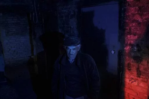 A resident stands inside a basement used as a bomb shelter during Russian attacks in a village recently retaken by Ukrainian forces near Kharkiv, Ukraine, Saturday, April 30, 2022. (AP Photo/Felipe Dana)