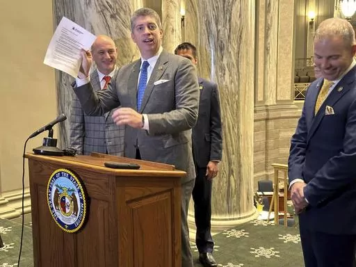 Missouri state Sen. Bill Eigel, a Republican member of the state Freedom Caucus, waives a paper containing criticisms of the Freedom Caucus that had been prepared by Republican Senate leaders for a press conference on Thursday, Jan. 25, 2024, at the state Capitol in Jefferson City, Mo. Republican leaders had left the paper on a lectern which the Freedom Caucus then used for its own press conference. (AP Photo/David A. Lieb)