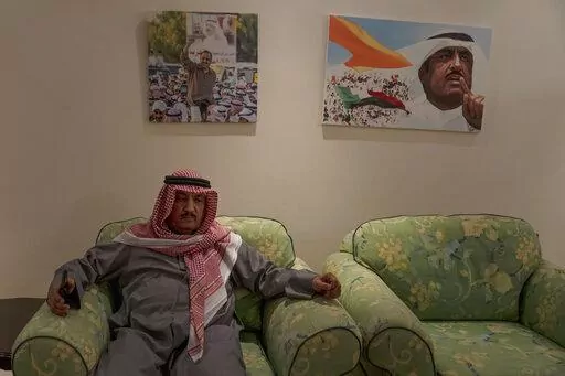Former opposition leader Musallam al-Barrak sits beneath a photo and painting of him during rallies, at his home in Kuwait City, Feb. 9, 2022. A decade ago, and against all odds, the surge of uprisings known as the Arab Spring reached emir-ruled Kuwait as dissidents stormed parliament and demanded the downfall of the prime minister. Al-Barrak and other dissidents, driven into exile have returned home to a country they say has only deteriorated in their absence. (AP Photo/Maya Alleruzzo)