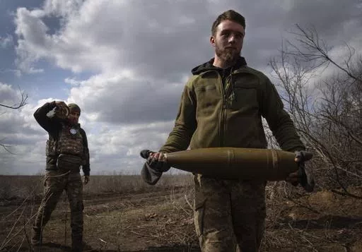 Ukrainian soldiers carry shells to fire at Russian positions on the front line, near the city of Bakhmut, in Ukraine's Donetsk region, on March 25, 2024. Approval by the U.S. House of a $61 billion package for Ukraine puts the country a step closer to getting an infusion of new firepower. But the clock is ticking. Russia is using all its might to achieve its most significant gains since the invasion by a May 9 deadline. (AP Photo/Efrem Lukatsky, File)