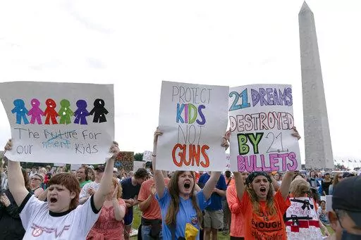 People hold signs in the second March for Our Lives rally in support of gun control in front of the Washington Monument, Saturday, June 11, 2022, in Washington. The rally is a successor to the 2018 march organized by student protestors after the mass shooting at a high school in Parkland, Fla. (AP Photo/Jose Luis Magana)
