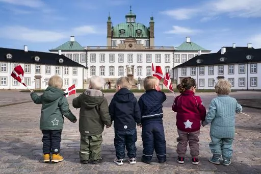 Children wave Danish flags as they celebrate Denmark's Queen Margrethe's birthday, in Fredensborg, Denmark, on April 16, 2021. Norway's top body for international adoptions on Tuesday recommended a halt to all adoptions from abroad for a two-year period pending an investigation into several allegedly illegal cases, while Denmark's sole overseas adoption agency announced it was stopping for the same concerns. (Martin Sylvest/Ritzau Scanpix via AP, File)