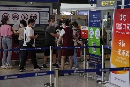 An airliner worker asks traveller to declare their health information after checking in at the international flight check in counter at the Beijing Capital International Airport in Beijing, Aug. 24, 2022. China will reopen its borders to tourists and resume issuing all visas Wednesday, March 15, 2023 after a three-year halt during the pandemic as it sought to boost its tourism and economy. (AP Photo/Andy Wong, File)